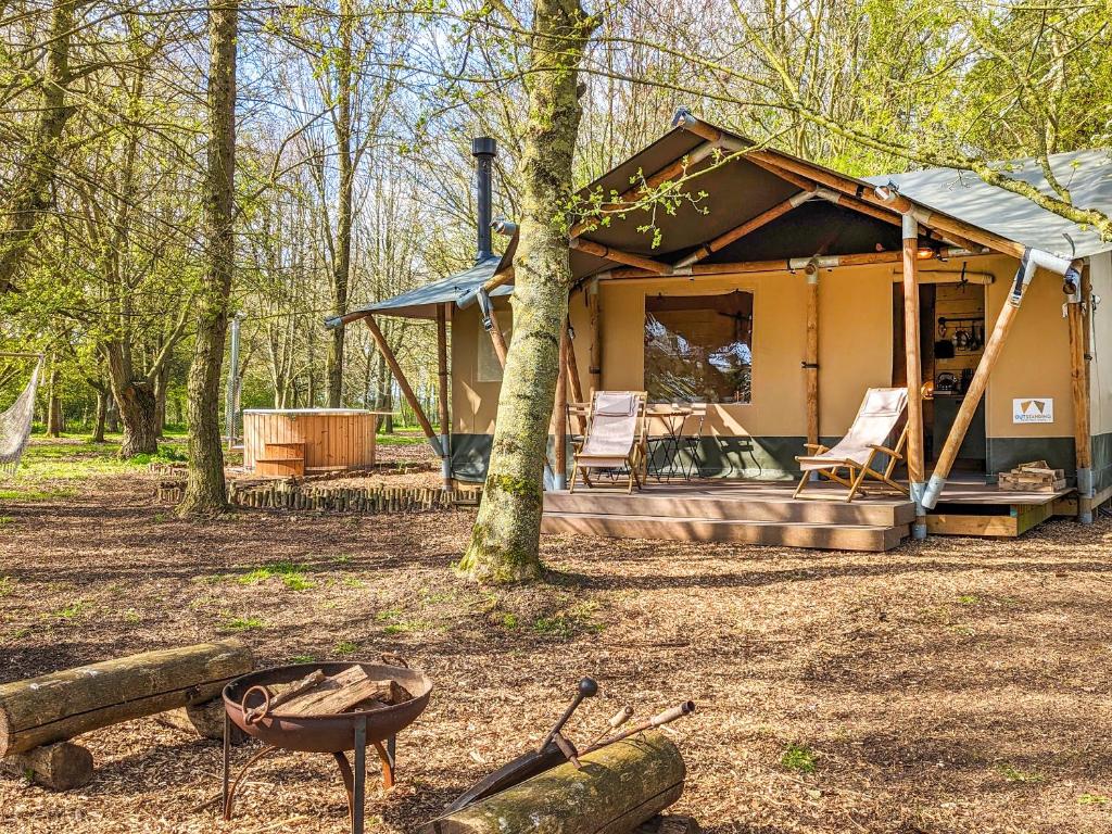 a house in the woods with a grill and chairs at The Bushel - Ukc7131 in Cratfield