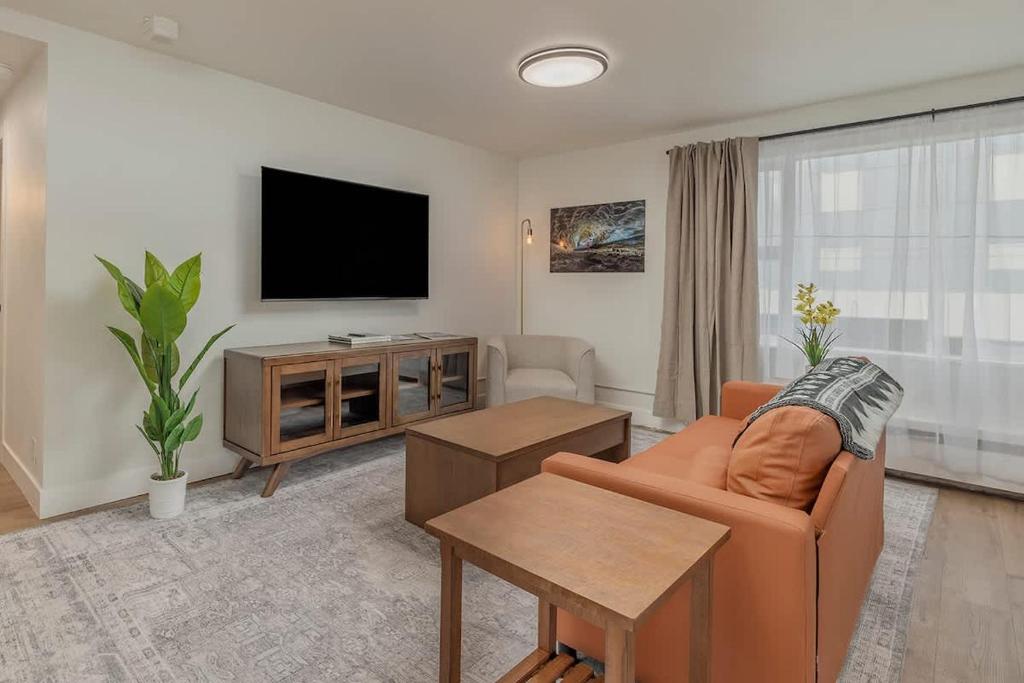 a living room with a couch and a flat screen tv at Downtown 1 Bedroom Flat with Views in Anchorage