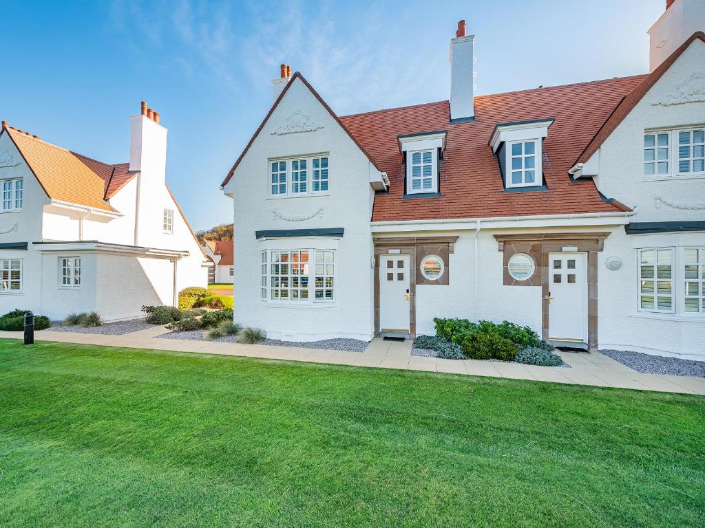 a large white house with a green lawn at Royal Dornoch - Ukc6918 in Turnberry