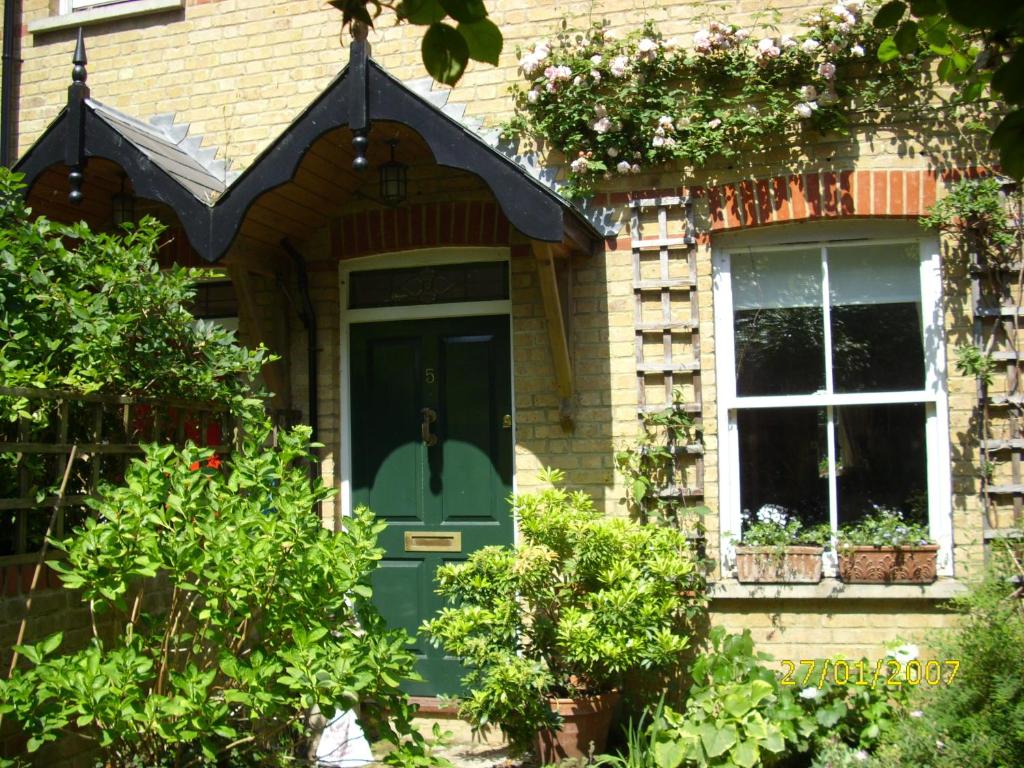 a house with a green door and a window at Old Station Gardens, SW London in Teddington