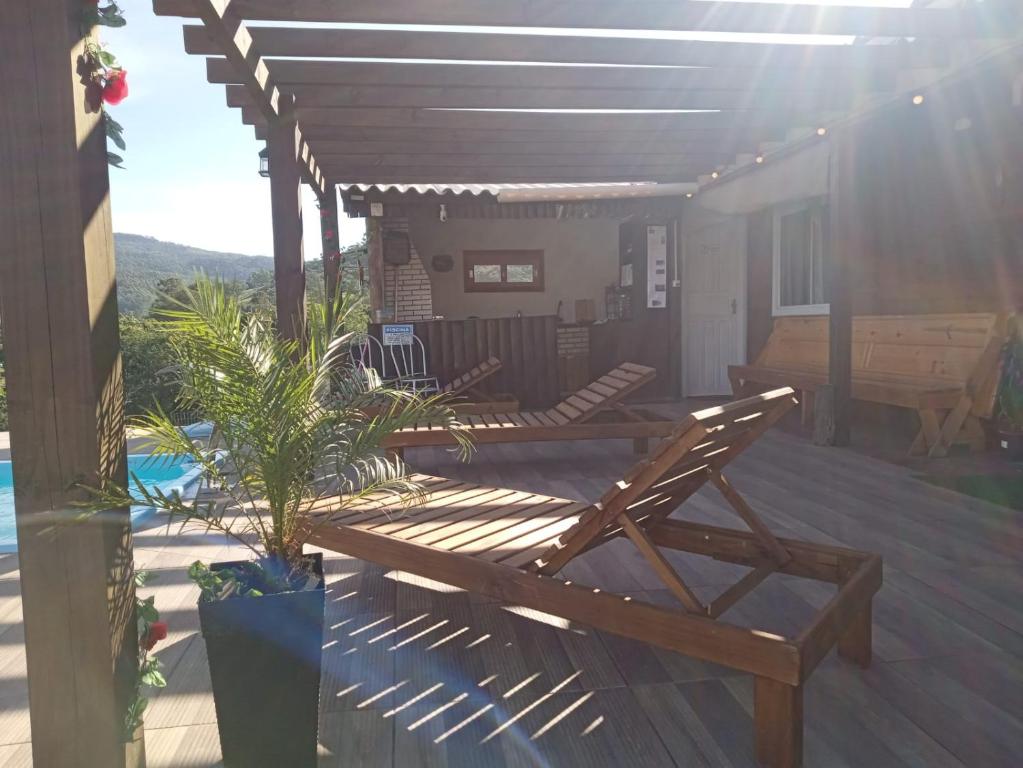 a wooden deck with a bench and a table at Recanto do SOL in Imaruí