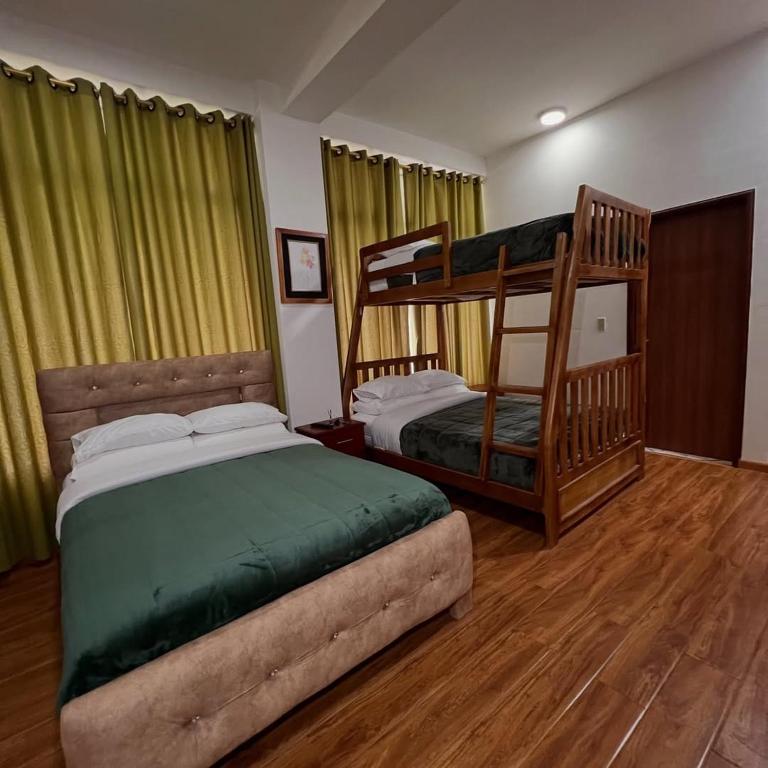 a bedroom with two bunk beds and a chair at Núba Hospedaje in Baños