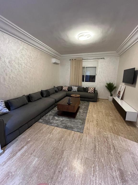 a living room with a couch and a table at Cozy Beach Apartment Diar Mansour Rabat in Rabat