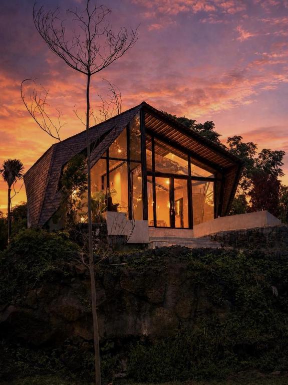 a house on a hill with large glass windows at Skylake Villa in Kubupenlokan