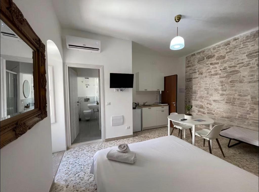 a bedroom with a bed and a table and a bathroom at Casa-Torre Normanna in Bitonto