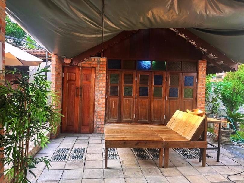 a wooden bench sitting in front of a building at Lelangit Inn in Port Dickson