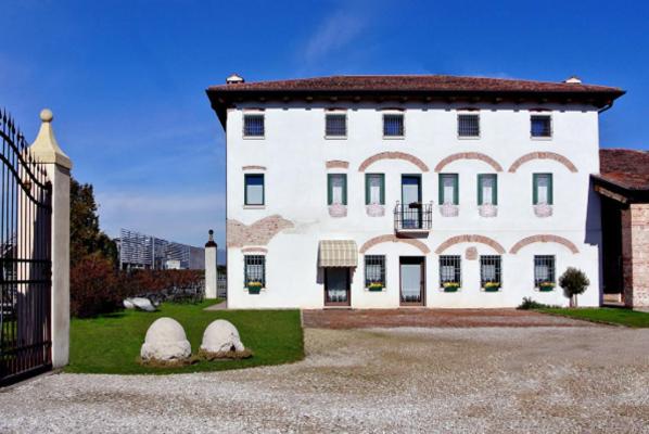 duży biały dom z bramą przed nim w obiekcie Agriturismo Sartori Terenzio w mieście Quinto Vicentino