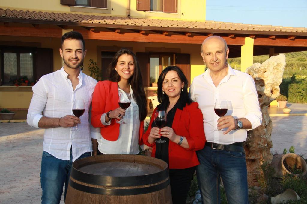 a group of people standing next to a barrel of wine at B&B Antico Frantoio in Sambuca di Sicilia