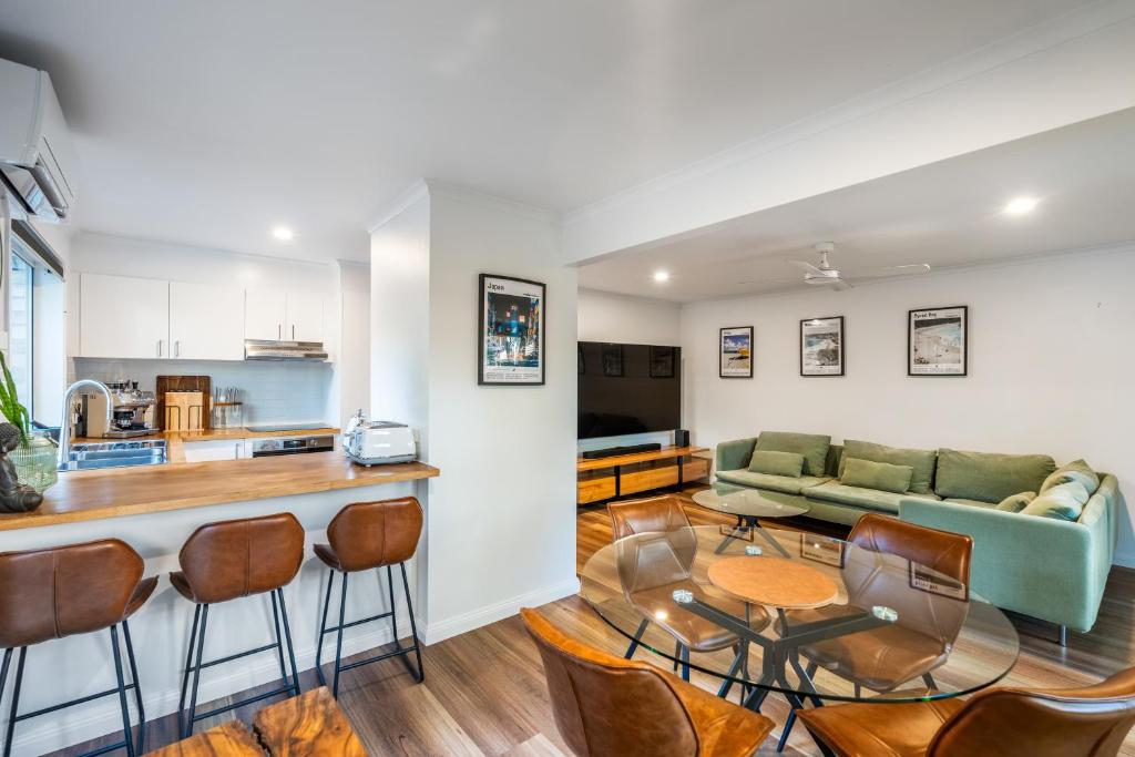 a kitchen and living room with a couch and a table at Treetops Sunrise Beach in Byron Bay