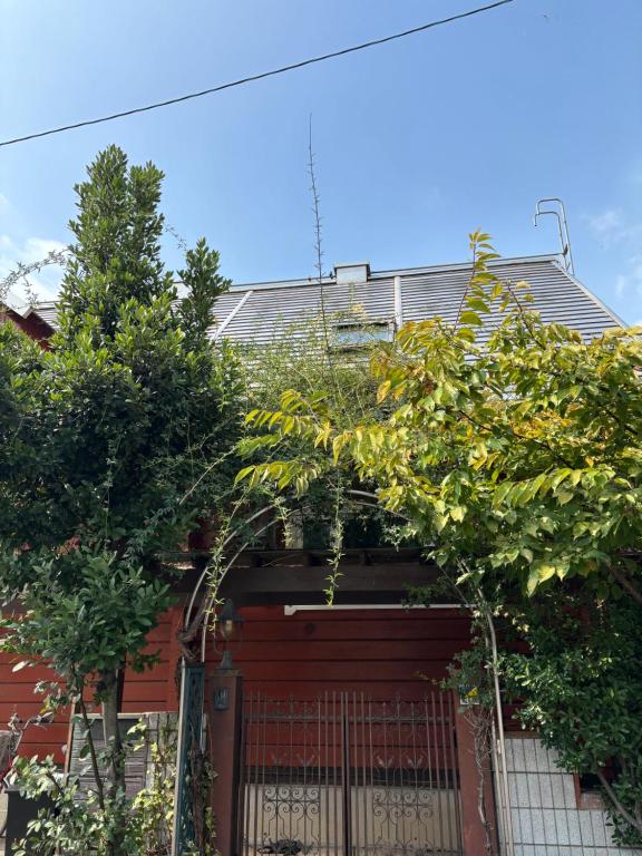 a house with a gate and trees in front of it at Based Inn Okayama Kurashiki in Okayama