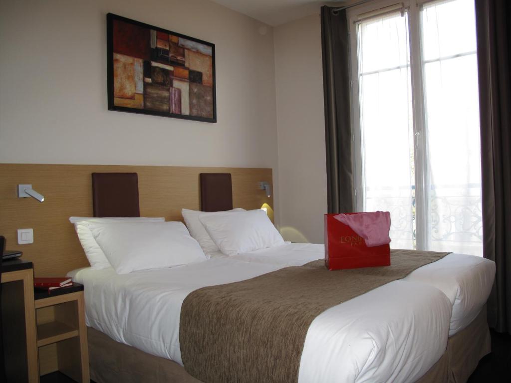Voodi või voodid majutusasutuse Source Hôtel toas