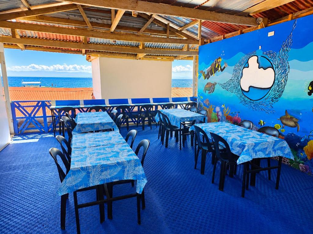 a restaurant with tables and chairs with a mural on the wall at 7641guesthouse in Basdiot