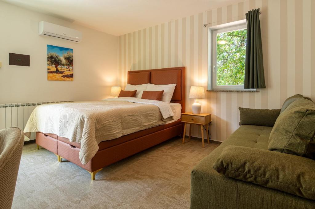 a bedroom with a bed and a couch and a window at B&B Villa Marta - New Opening 2026 in Medulin