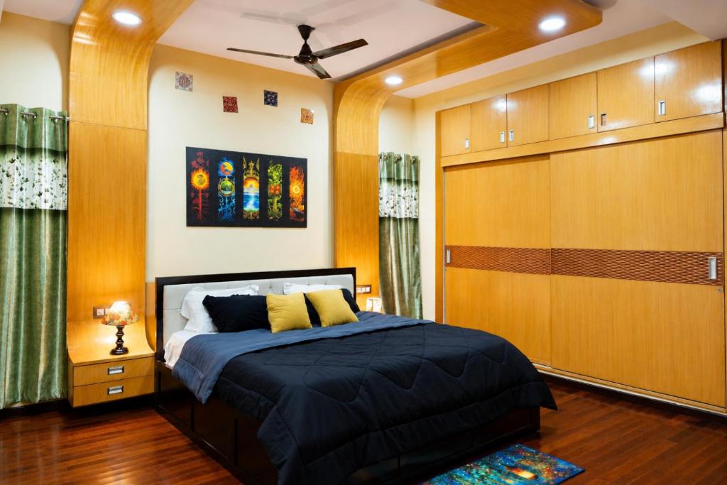 a bedroom with a bed and a ceiling fan at Prana pulse villa stay gokulam in Mysore