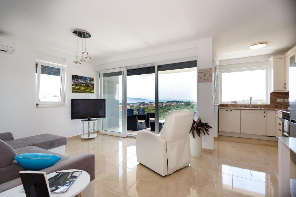 a living room with white furniture and large windows at Apartment Marinela in Krk