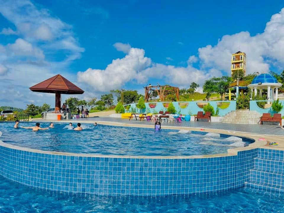 a swimming pool at a resort with people in the water at Highland Park Mondulkiri in Phumĭ Pu Klé (2)