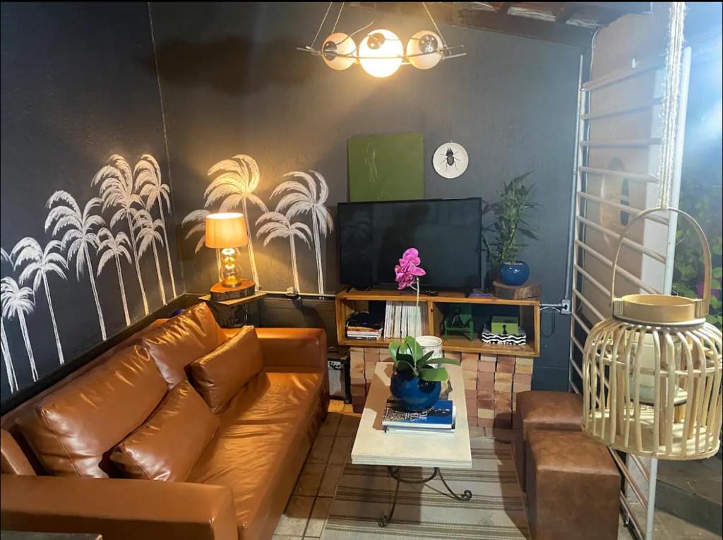 a living room with a couch and a tv at BACKHOUSE Vieiralves - Manaus in Manaus