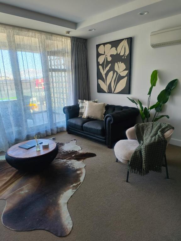 a living room with a couch and a table at 204 The Sands in Nelson