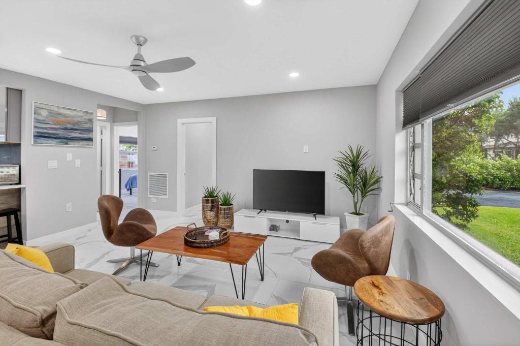 a living room with a couch and chairs and a tv at Marina Row 4 Beach Shops in Delray Beach