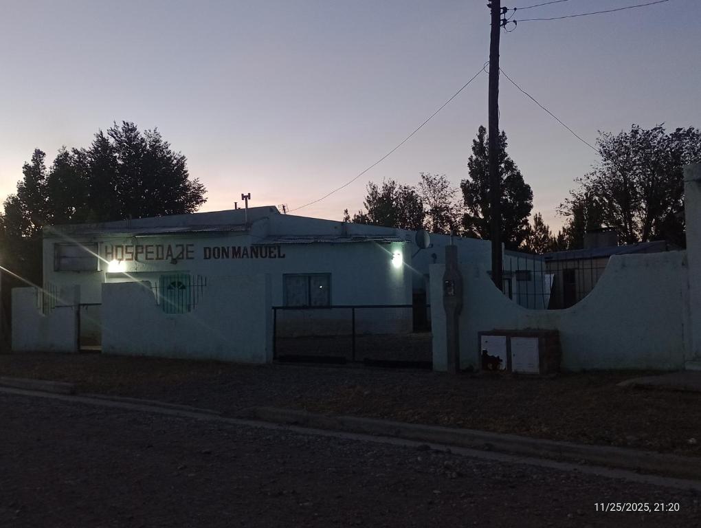 a white building with a sign on the side of it at Hospedaje DON MANUEL in Paso de Indios