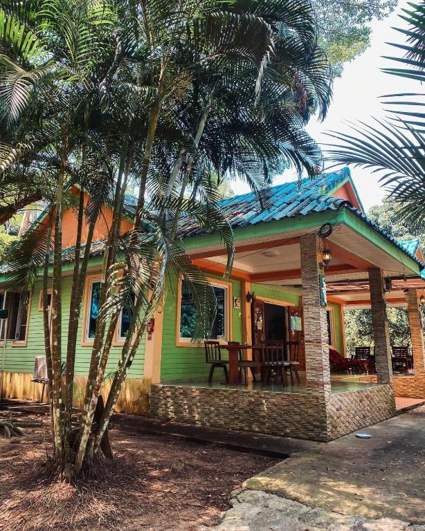 a green house with a palm tree in front of it at Kama Siri Koh Kood in Ko Kood