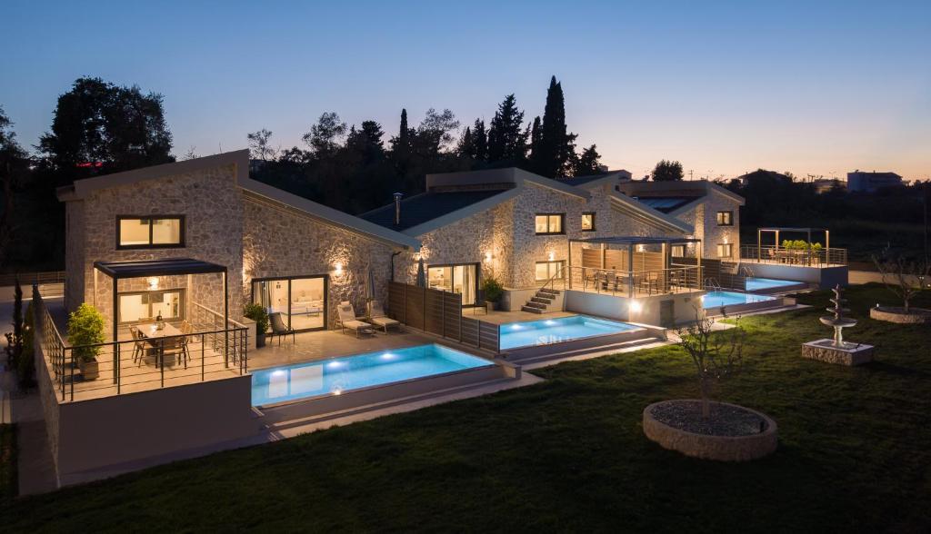 a large house with two swimming pools in the yard at Vagg Villas in Preveza