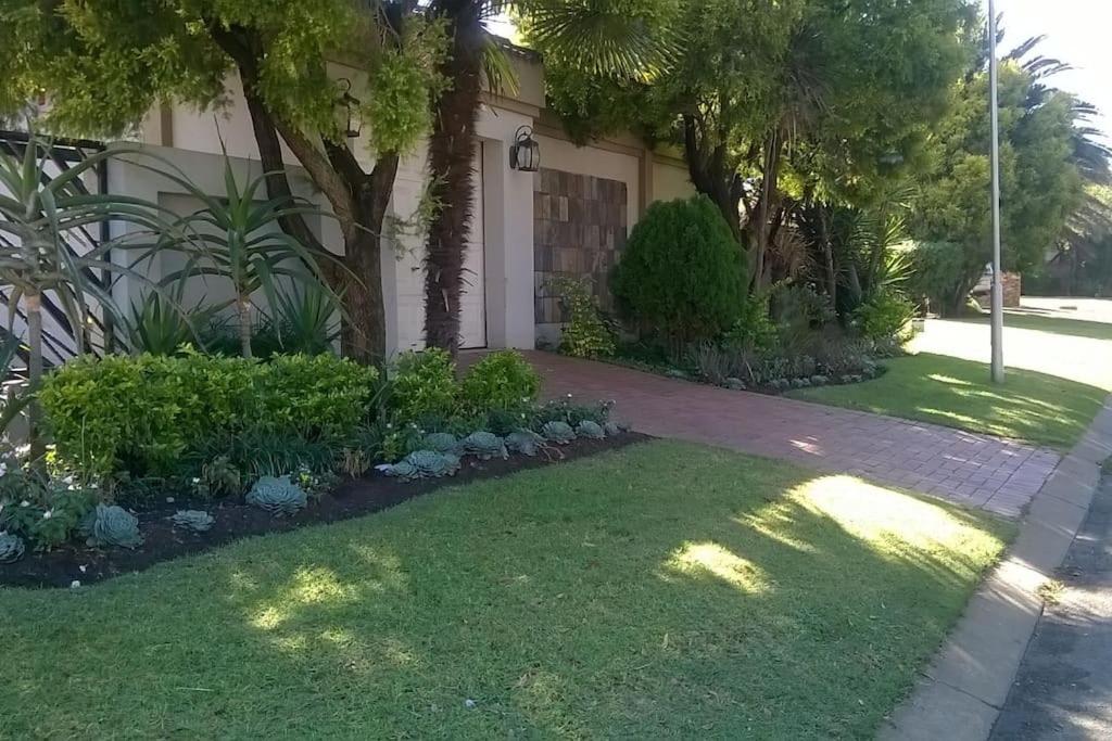 a house with a yard with green grass and trees at East Cottage in Boksburg