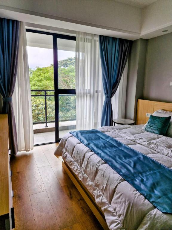 a bedroom with a bed and a large window at Laurel Haven Abode in Nairobi