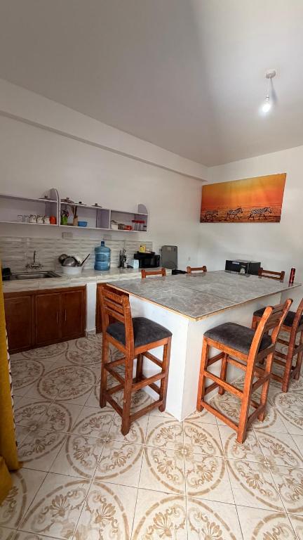 a kitchen with a large counter with two chairs and a table at the velvet nest in Watamu