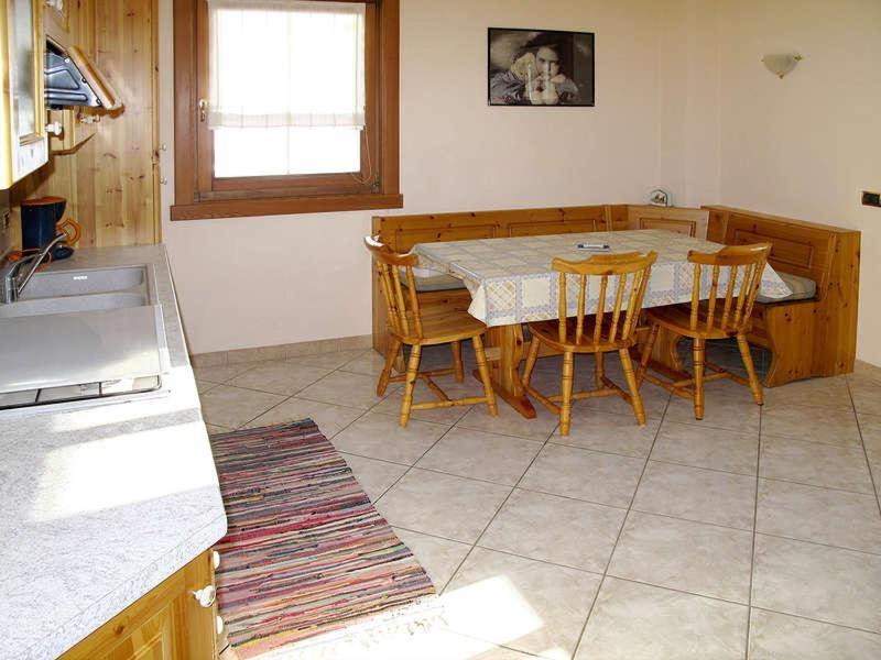 uma cozinha com uma mesa e cadeiras numa cozinha em Bait da Giusy em Livigno