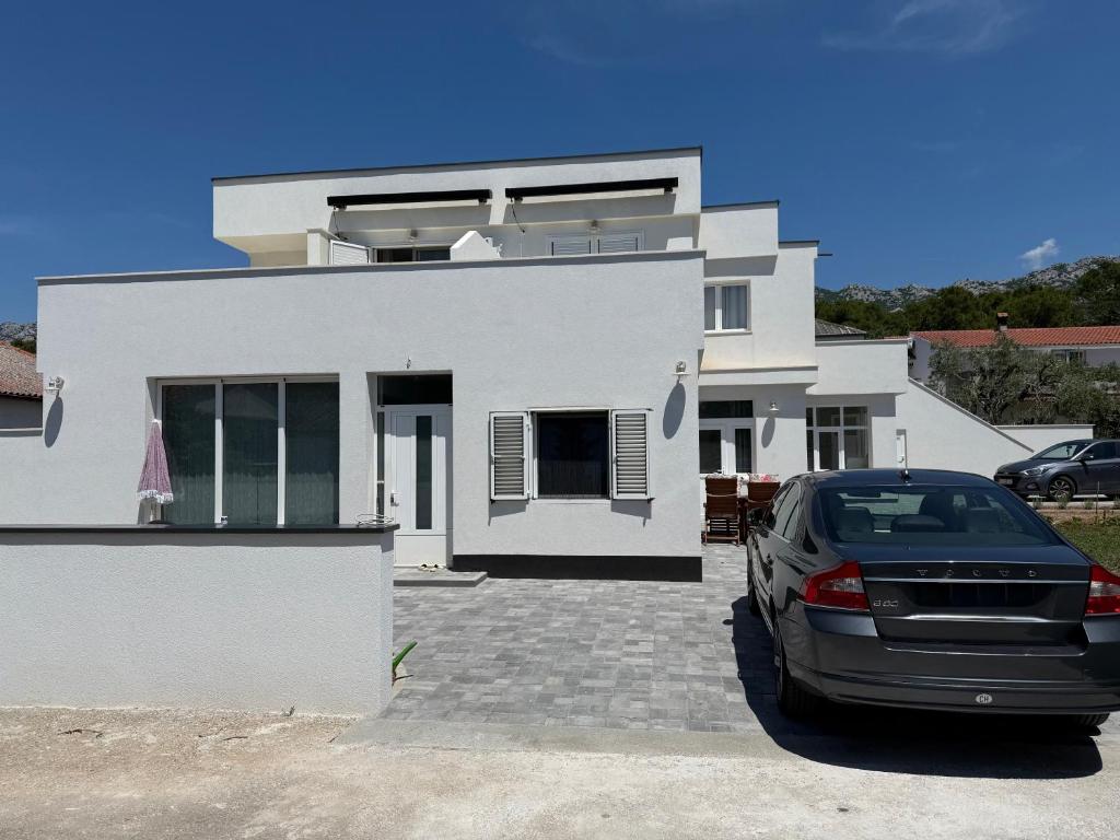 a white house with a car parked in front of it at Apartment daal Seline in Seline