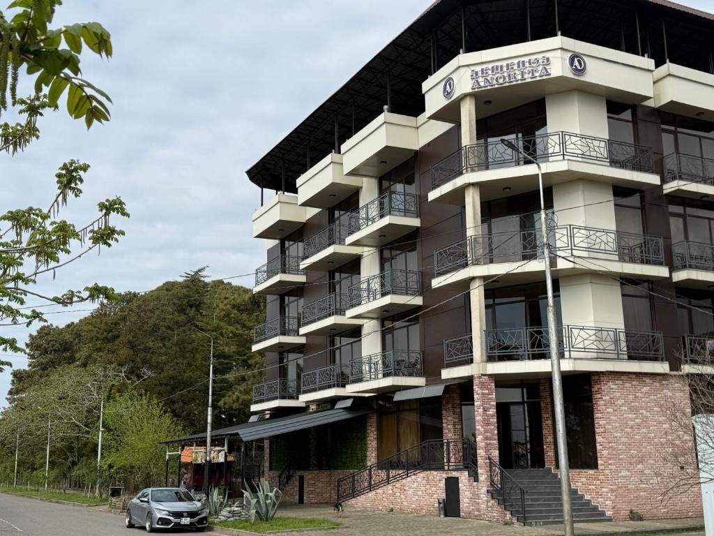 an apartment building with a car parked in front of it at Hotel AnOrita in Kobuleti