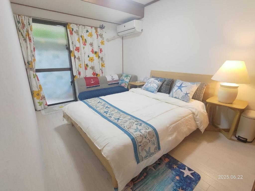 a bedroom with a large bed and a window at Green Hights Residence-101 in Naha