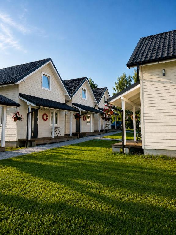 a row of houses with a grass yard at Domki 7 Houses Rewal in Rewal