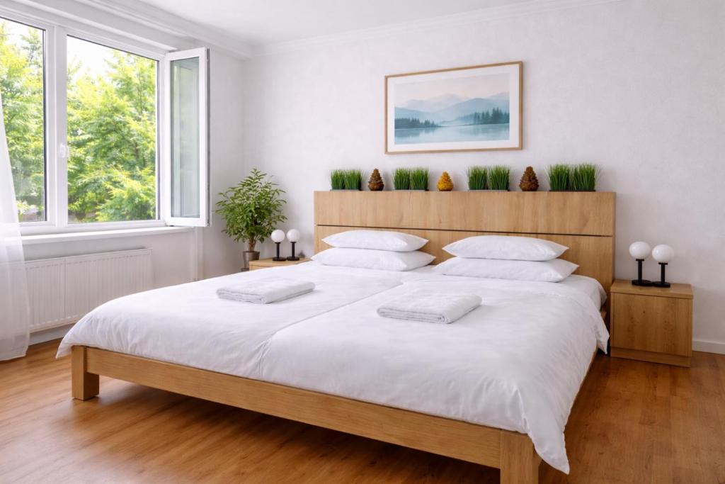 a bedroom with a large bed with white sheets and pillows at Comfort 28 - Great Value Apartment with Full Kitchen in Miskolc
