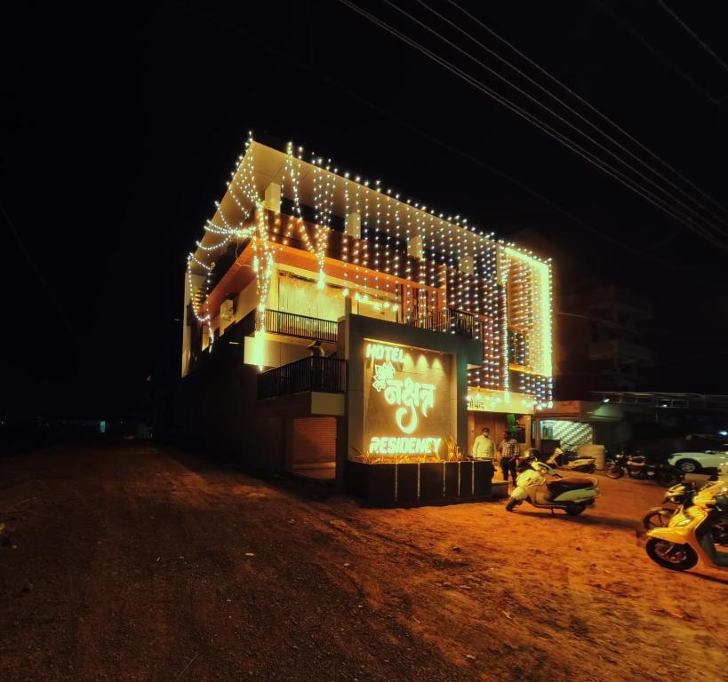 a building with christmas lights on it at night at Hotel Nakshtra Residency in Bramhapuri