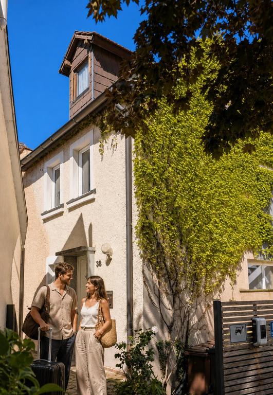 a man and a woman standing in front of a building at Ferienhaus am Main in Veitshöchheim
