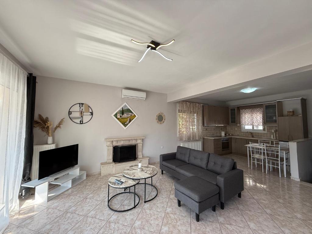 a living room with a couch and a tv at Crystal seaview home in Iraklitsa