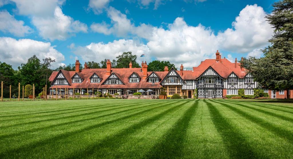 a large house with a large grass field at Petwood Hotel in Woodhall Spa