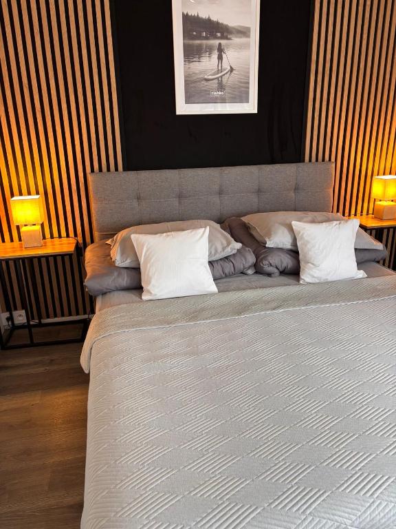 a bedroom with a large bed with two lamps at rishko resort - Lake View - free Parking - 24hr Self chceck-in - Serviced Apartment Premium by Hotelstars Union in Holčíkovce