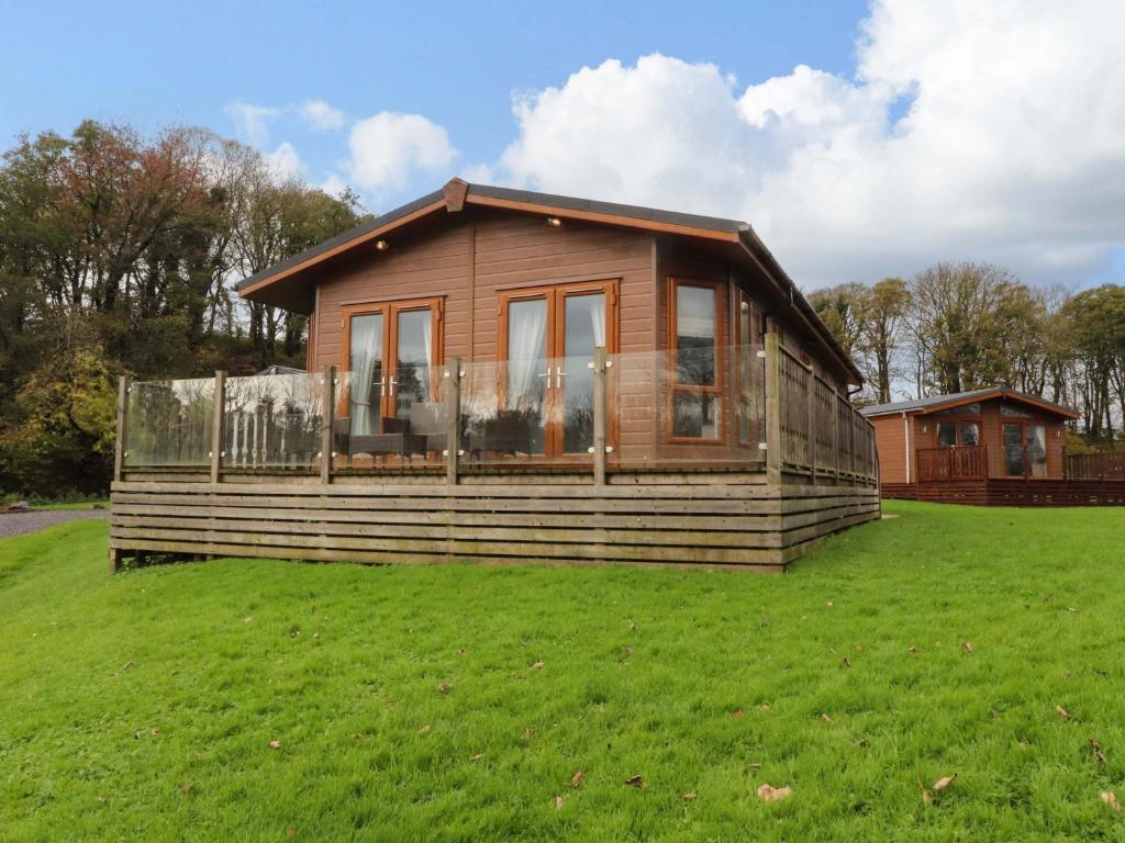 a small wooden house on a grass field at Lakeview Lodge in Preston