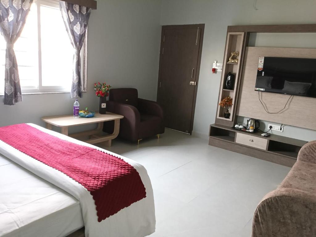 a bedroom with a bed and a tv and a chair at S&J Hotel & Banquet in Bhabua