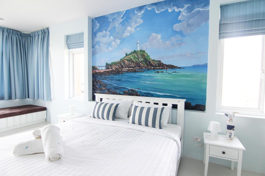 Un dormitorio con una cama blanca y una pintura del océano en Just Fine Krabi, en Krabi