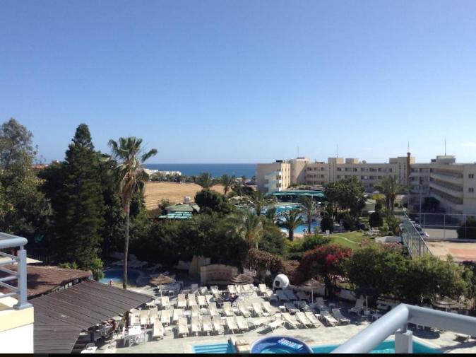 Blick auf ein Resort mit einem Pool, Tischen und Stühlen in der Unterkunft Paphos Studios in Paphos City