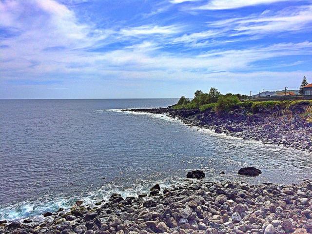 a rocky shoreline with a house and the ocean at TINA 3B - Alojamento Local - RRAL 760 in Porto Martins