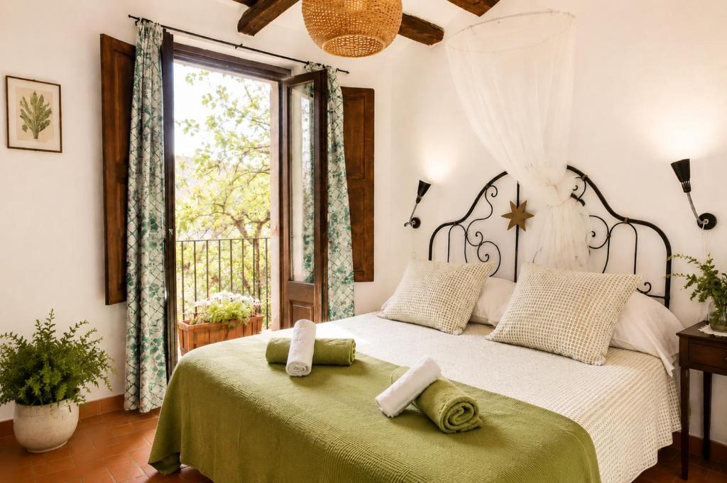 a bedroom with a large bed with towels on it at Casa amb terrassa i vistes a la vall - Cal Taverner in Montsonis