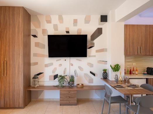 a living room with a table and a television on a wall at Bill Apartments in Patra