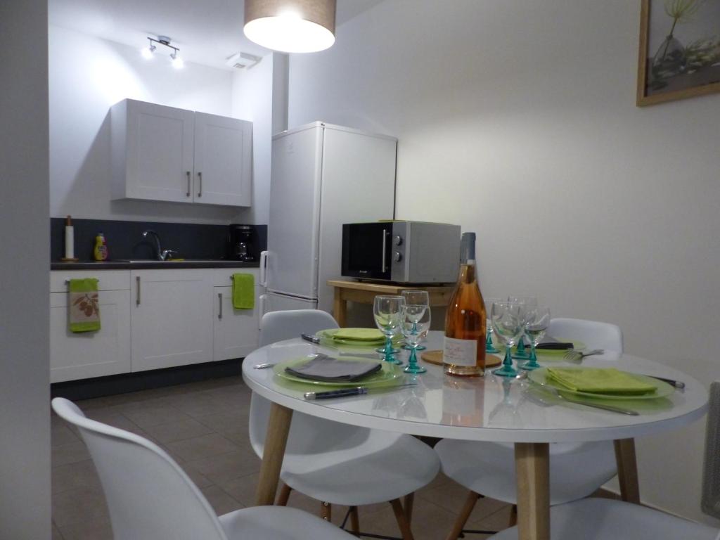 - une cuisine avec une table et des chaises ainsi qu'une bouteille de vin dans l'établissement Appartement Plein Centre Avignon, à Avignon