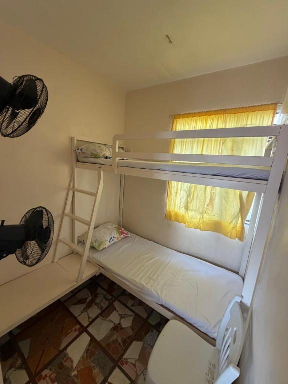 a small room with two bunk beds and a window at Maria Kulafu Lodging House Pier site- Santa Clara office 2nd Floor in Cagba
