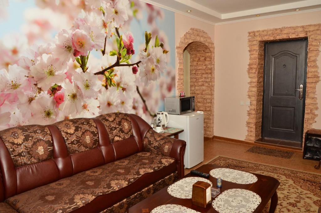 a living room with a couch and a flower wall at Guest House Domashniy Uyut in Bishkek